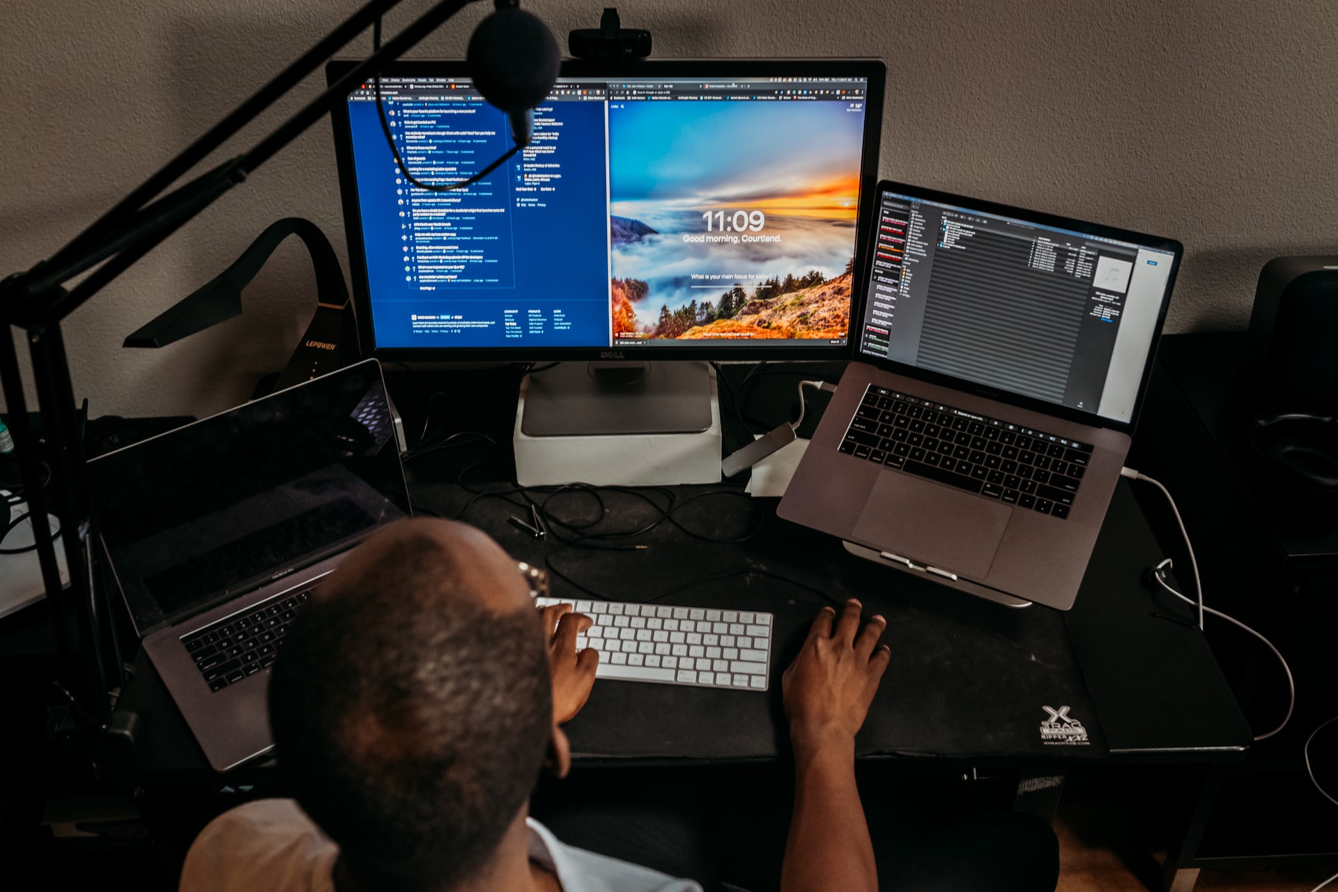 a man working on a project using multiple screens and laptops